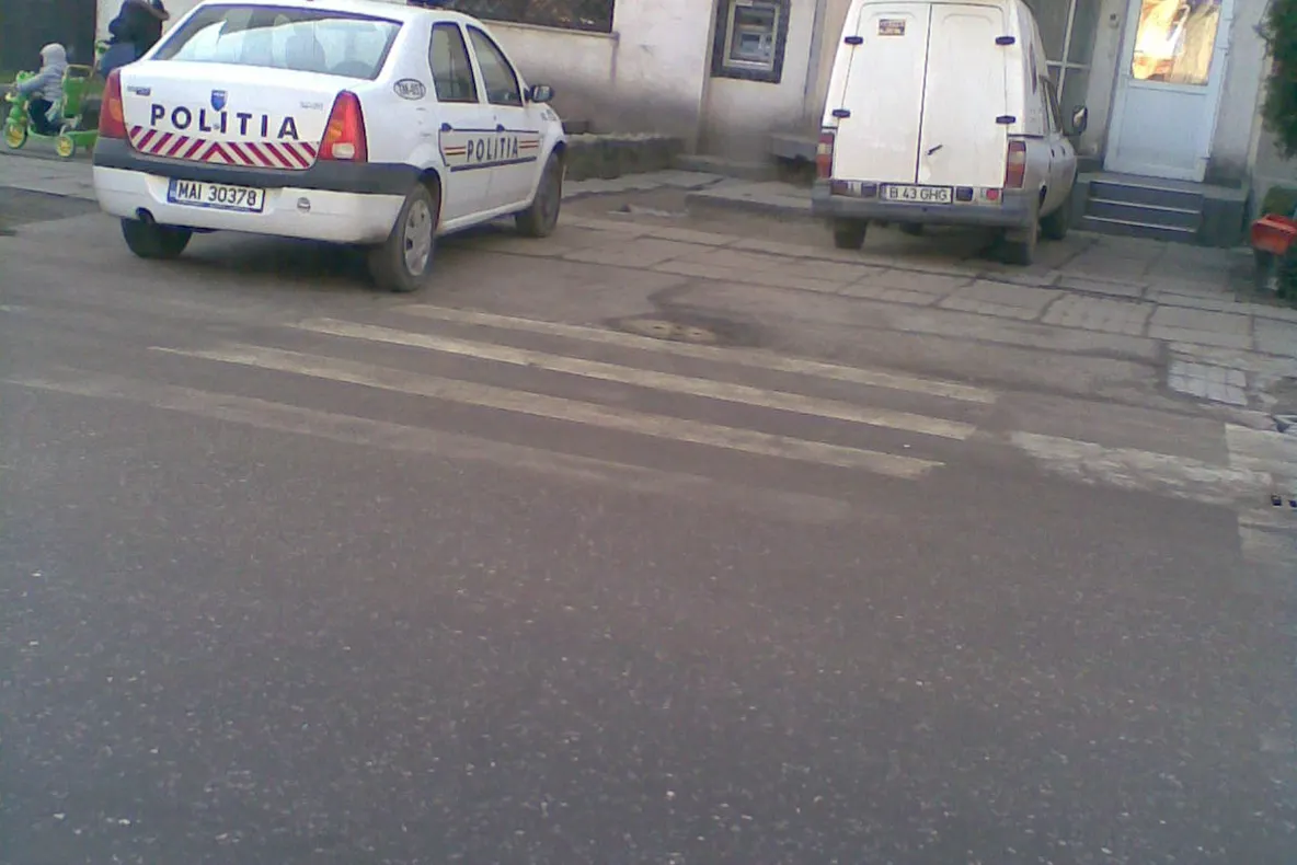 O maşină a poliţiei a fost parcată pe trotuar, exact lângă trecerea de pietoni