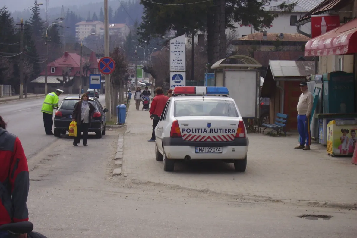 Maşina poliţiei din Buşteni parcată pe trotuar, în staţia de autobuz