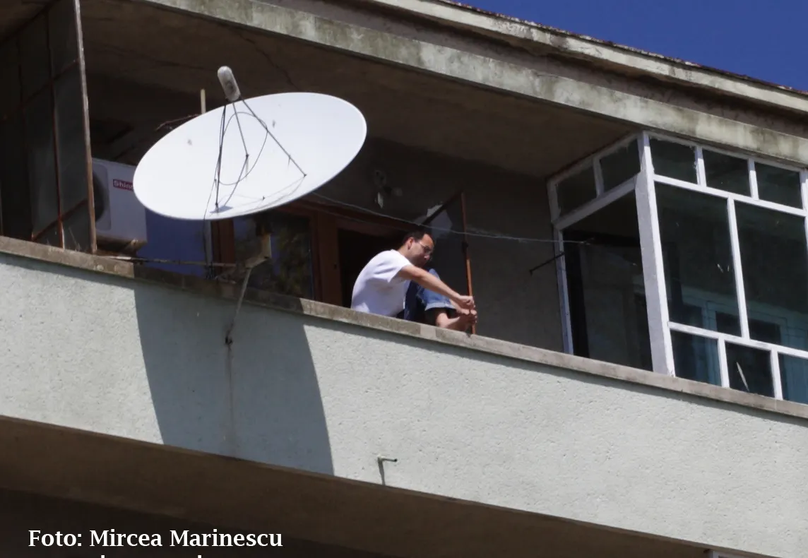 Deasupra falezei din Constanţa, un locatar îşi face pedichiura pe balcon