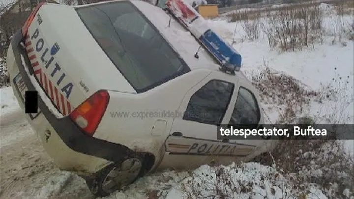 O maşină de poliţie a derapat şi a rămas împotmolită pe marginea drumului
