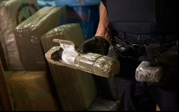 Traficanți prinși de polițiști în timp ce ridicau un colet de 4 kg de canabis