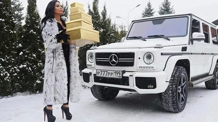 Această tânără stă cu un morman de cutii în braţe pe marginea drumului. Ce face, de fapt!