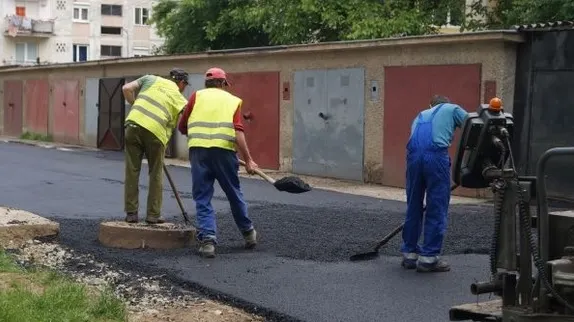 Situaţie halucinantă la Craiova! Asfaltare cu obstacole. Au turnat covorul în jurul maşinilor 