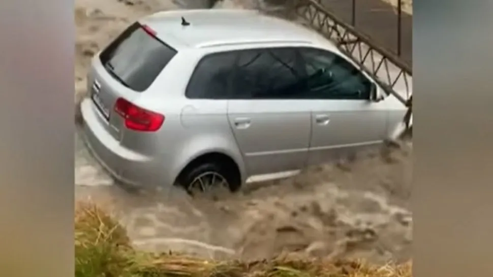 VDEO Șofer, la un pas să-și piardă viața! Mașina sa a fost luată de ape și răsturnată