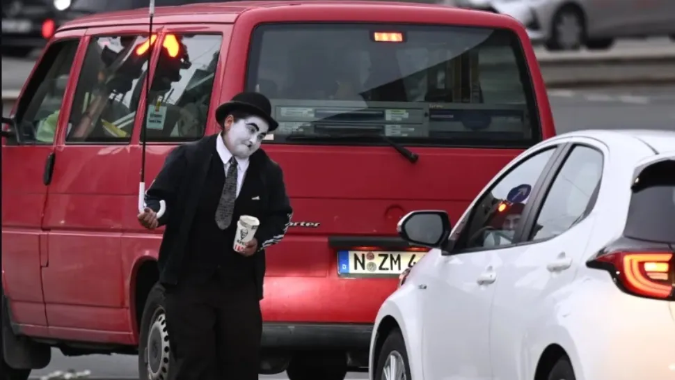 Povestea a doi români care cerșesc în Germania deghizați în Charlie Chaplin. Noaptea dorm pe străzi, iar ziua fac spectacol la semafoare