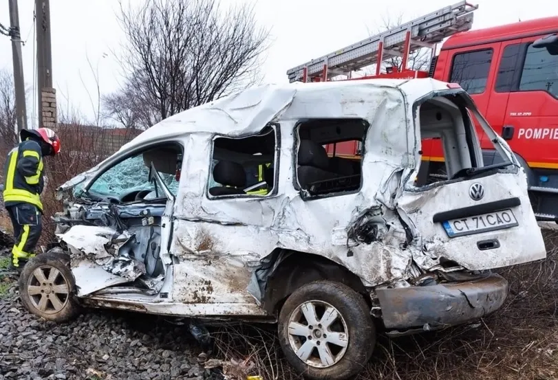 A scăpat cu răni ușoare după ce mașina i-a fost lovită de un TIR, apoi de tren
