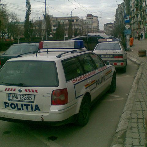 Un bărbat care a fotografiat două maşini de poliţie parcate neregulamentar a fost dus la secţie