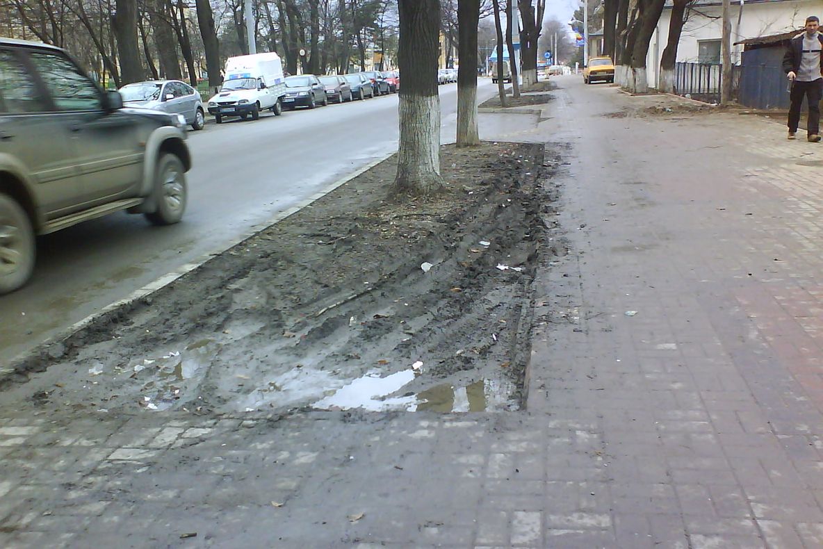 Un trotuar proaspăt amenajat, plin de noroi