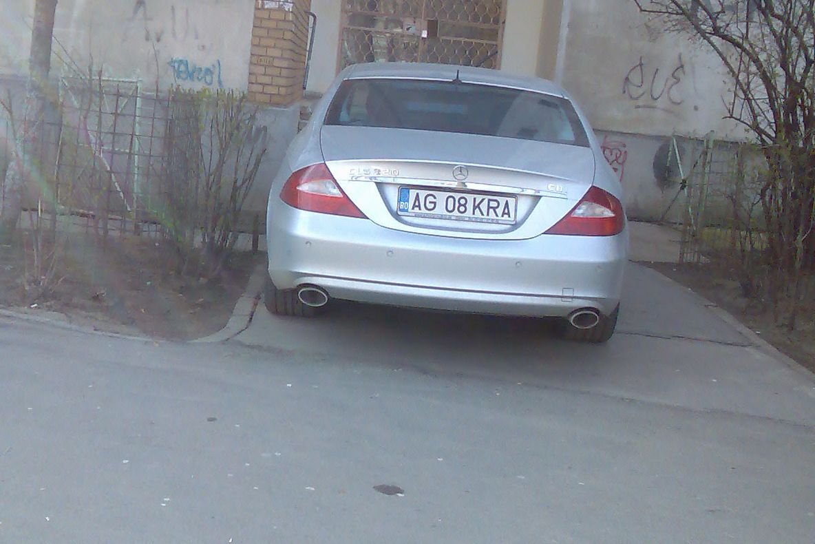 Maşină parcată în dreptul uşii de intrare în bloc, în Argeş