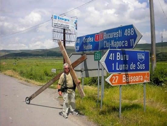De 26 de ani duce o cruce imensă pe umeri. Aventura unui turist care a ajuns şi în România