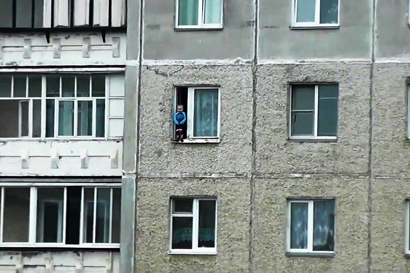 VIDEO ŞOCANT. La un pas de moarte. Un copil se joacă pe pervazul geamului, în picioare, la etajul 8