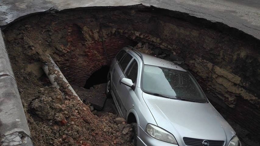 Maşină înghiţită de un crater uriaş surpat în parcare. Ce ascundea groapa şi de ce NU va fi astupată