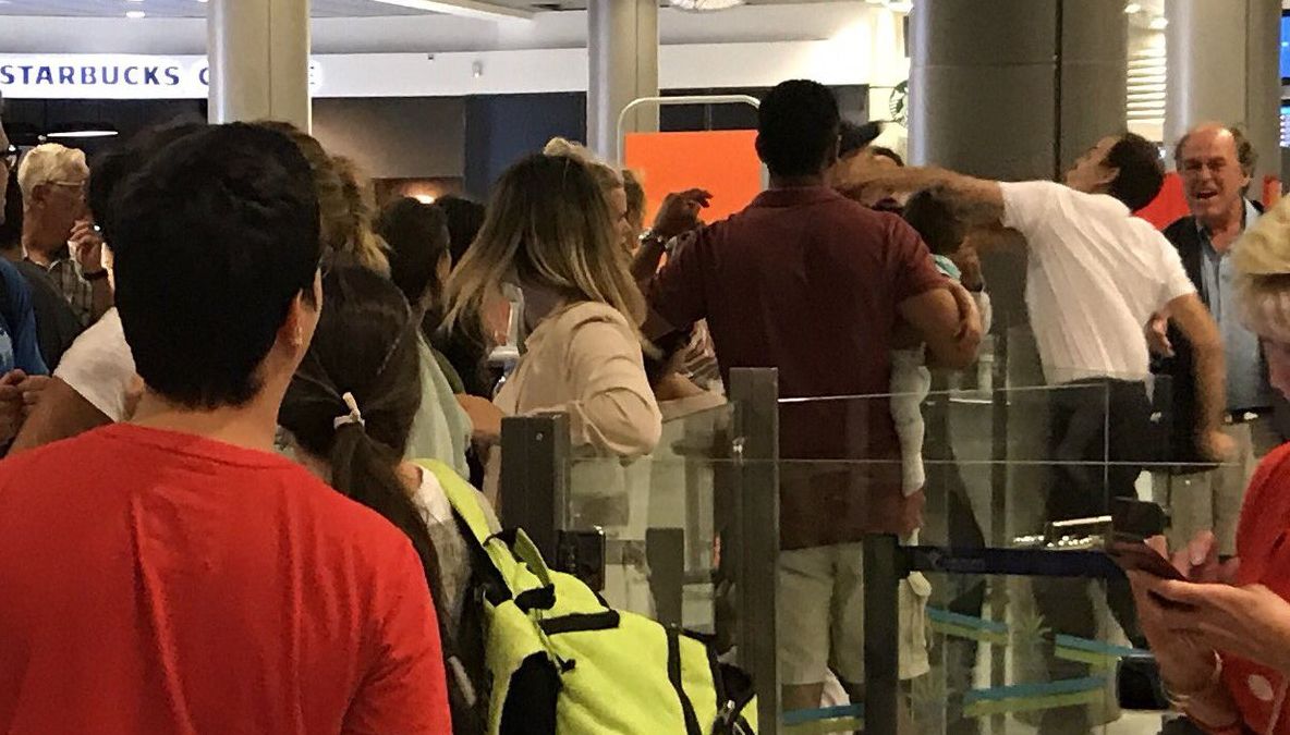 Imagine şocantă: un bărbat care îşi ţine bebeluşul în braţe, lovit de un angajat al aeroportului 