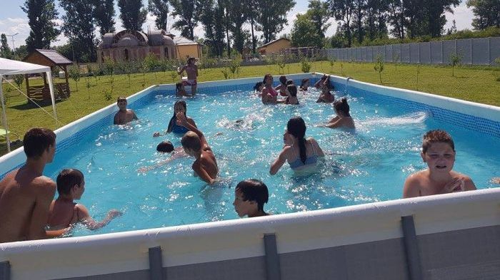 La scăldat în curtea bisericii! Așa scapă de caniculă copiii din județul Teleorman