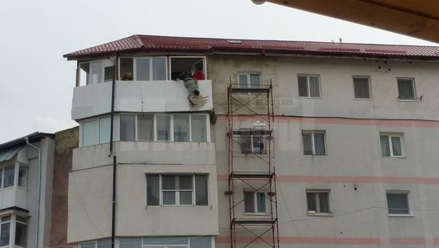 Cum se izolează un bloc în România? Muncitor ținut cu capul în jos de un alt coleg, de la etajul 5