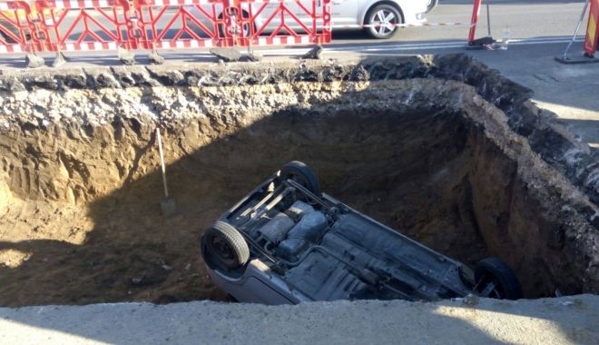 GALERIE FOTO. Un şofer a căzut cu maşina într-o groapă adâncă de cinci metri peste un muncitor