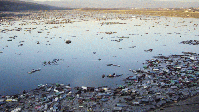 Poluare la cote maxime: râul Jiu, acoperit de gunoaie