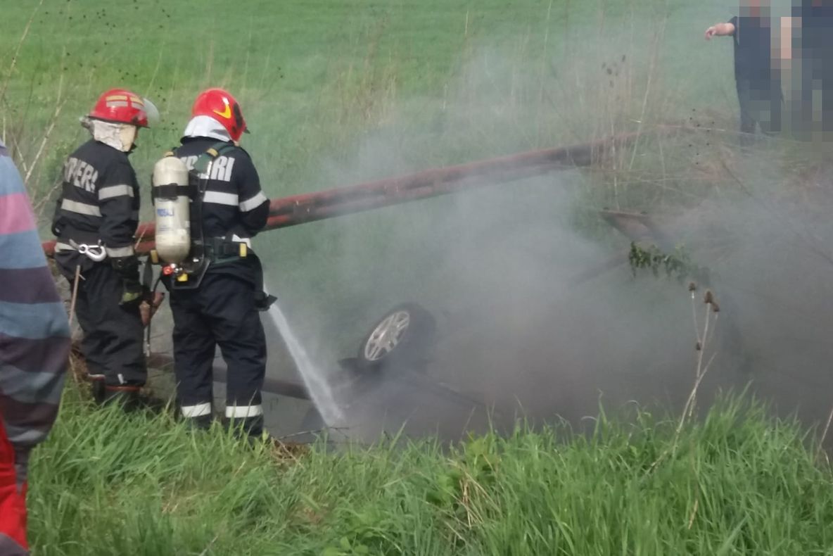 Imagini cumplite: O mașină a luat foc după ce s-a răsturnat într-un șanț. 5 victime