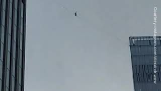 Bărbat surprins că merge pe sârmă între zgârie-nori 