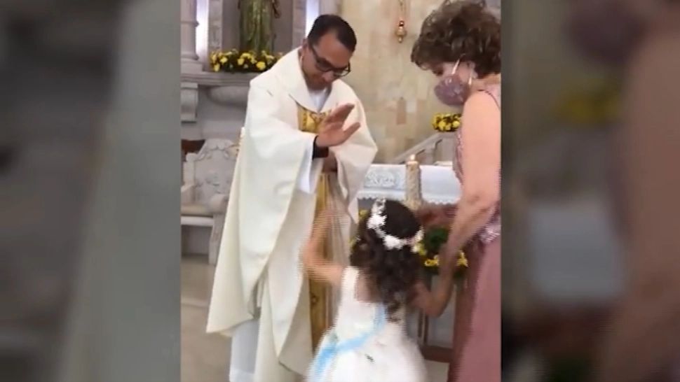 VIDEO O fetiță a interpretat greșit gestul de binecuvântare al unui preot. Imaginile au făcut turul internetului
