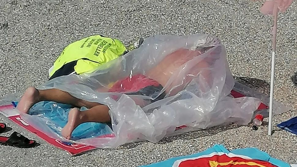 Imagini surprinzătoare, în Eforie Nord. Un bărbat se bronzează într-un sac de plastic