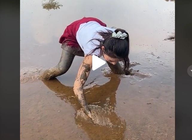 VIDEO – A văzut ceva în apă și s-a băgat în nămol până la gât – Ce a putut scoate, cu mâinile goale, după câteva minute