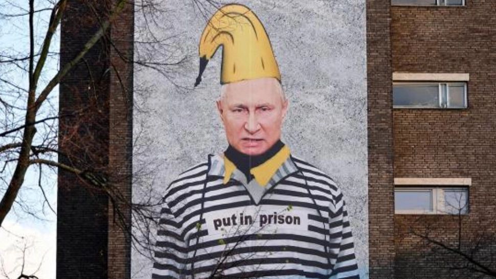 PUTIN, pe zidul unei clădiri dintr-un mare oraș, în haine de deținut și cu o banană în cap - Cine e autorul protestului