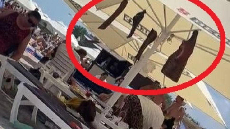 VIDEO – Din cauza prețurilor, un turist a venit la Costinești cu coaste și șuncă afumate de acasă și le-a atârnat de umbrela de pe plajă