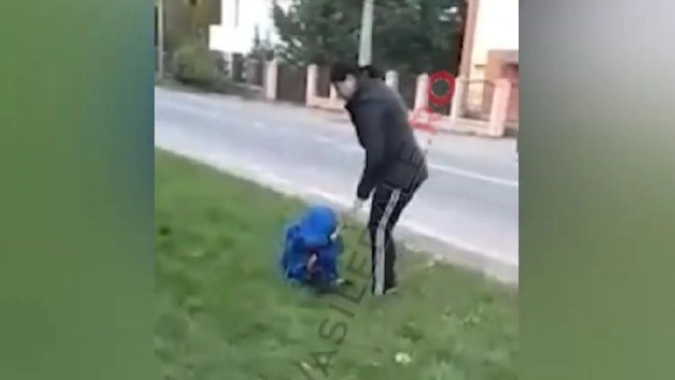 Mamă filmată când își bătea copilul cu piciorul în cap, în fața unei școli. Băiatul plângea și o ruga să înceteze - VIDEO