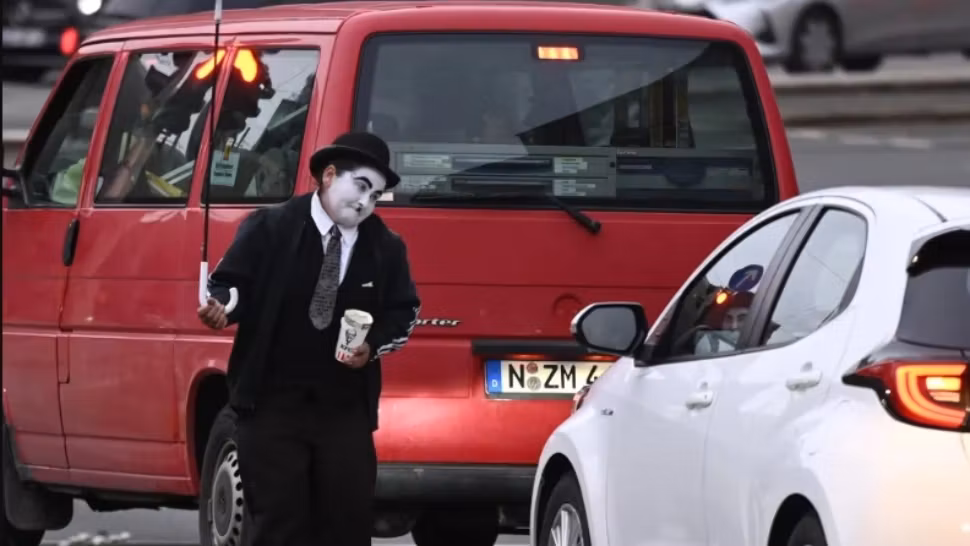 Povestea a doi români care cerșesc în Germania deghizați în Charlie Chaplin. Noaptea dorm pe străzi, iar ziua fac spectacol la semafoare