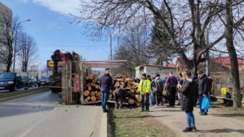 O remorcă plină cu bușteni s-a răsturnat pe un trotuar din Pașcani! 4 femei au fost rănite