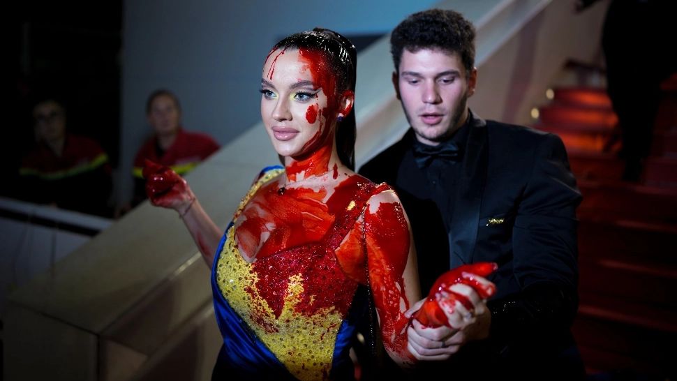 O femeie s-a vopsit cu sânge fals pe covorul roșu de la Cannes. Ce a determinat-o să facă acest gest