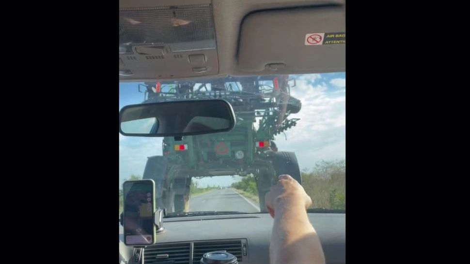 Inconștiență maximă pe străzile din România - Un șofer a trecut cu mașina pe sub un utial agricol, pe un drum public - VIDEO