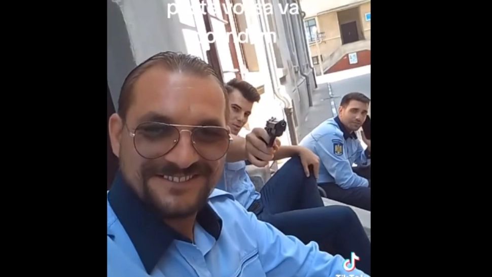 Polițiști falși, filmați în timp de flutură un pistol. „Venim peste voi să vă colindăm”