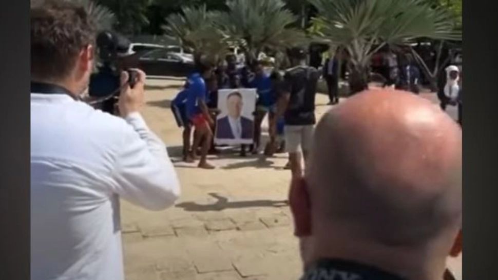 VIDEO - Dans ciudat al africanilor cu fotografia lui Klaus Iohannis - se aruncă în apă cu portretul președintelui, în timp ce strigă "Hakuna matata!"