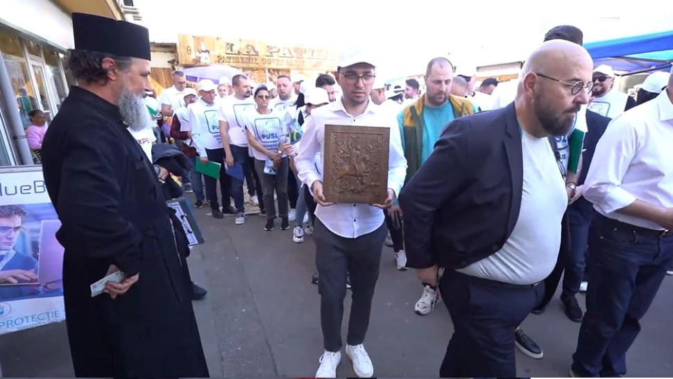 Piedone e generos în campanie electorală. Edilul, surprins când dă bani unui călugăr, într-o piață din Capitală: cu ce sfânt se compară VIDEO