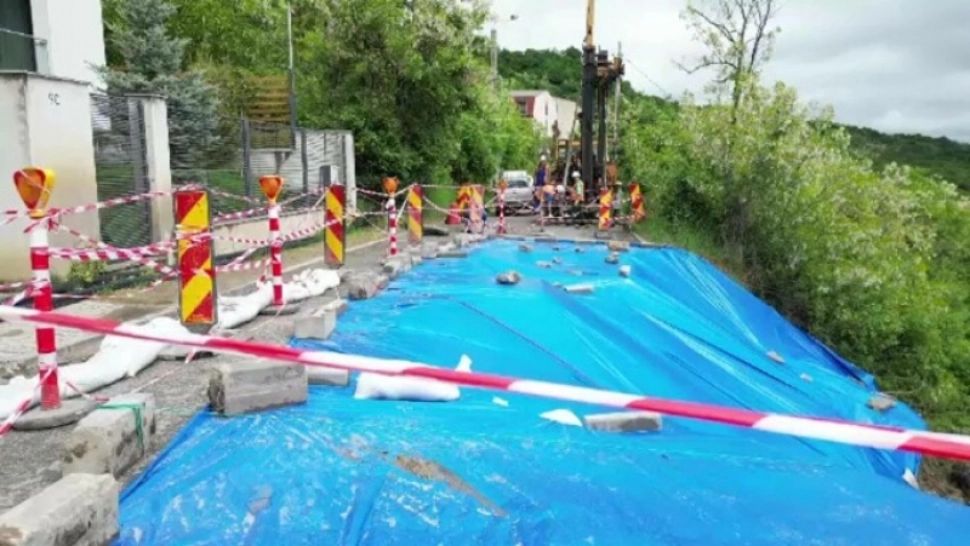 Stradă afectată de o alunecare de teren din Cluj-Napoca, acoperită temporar cu o prelată. Metoda „ingenioasă” folosită de autorități