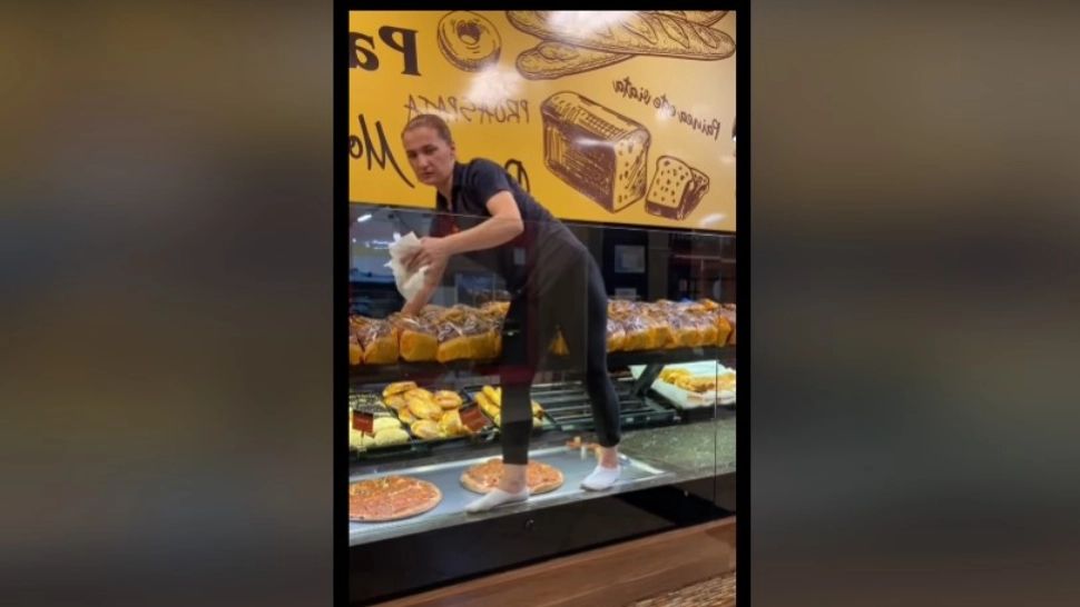 Video scandalos! Angajata unei patiserii s-a urcat cu picioarele pe rafturile pline cu produse pentru a igieniza geamurile - VIDEO