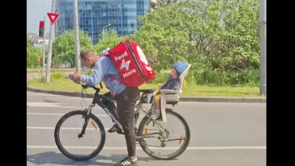 Un tată devotat, surprins livrând pe bicicletă cu fiul adormit în spate. Imaginile au stârnit valuri de emoție pe TikTok - VIDEO