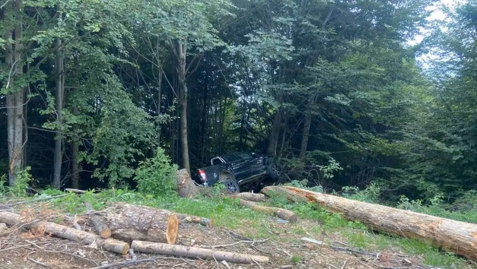 Accident cumplit în Vâlcea: o mașină s-a răsturnat și a rămas agățată de un copac. Victimele sunt o femeie și doi copii