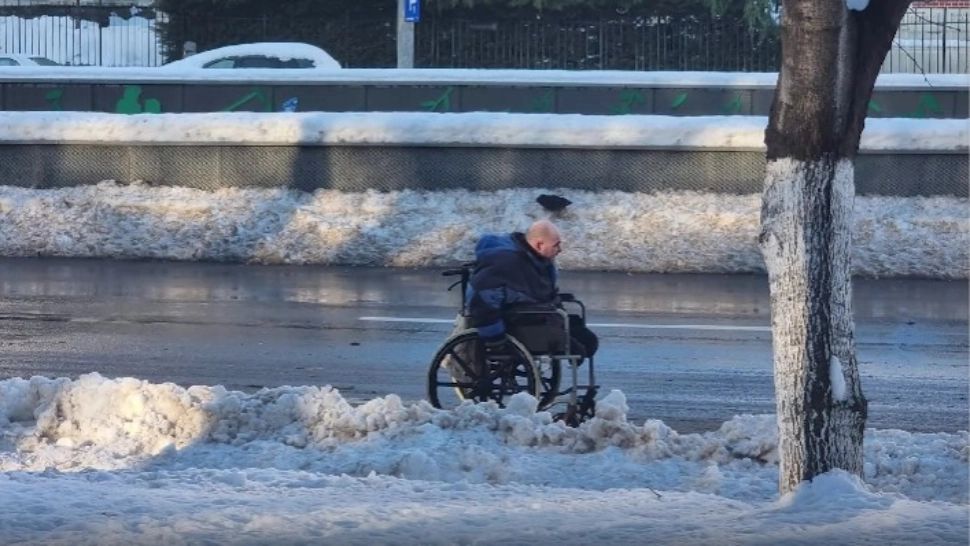 Om în scaun cu rotile, în zăpada din București. Imagini de pe cel mai circulat bulevard | VIDEO