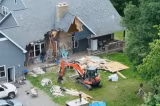 Un bărbat și-a demolat casa cu excavatorul după ce soția a cerut divorțul. Familia se afla în interior în timpul scenei șocante