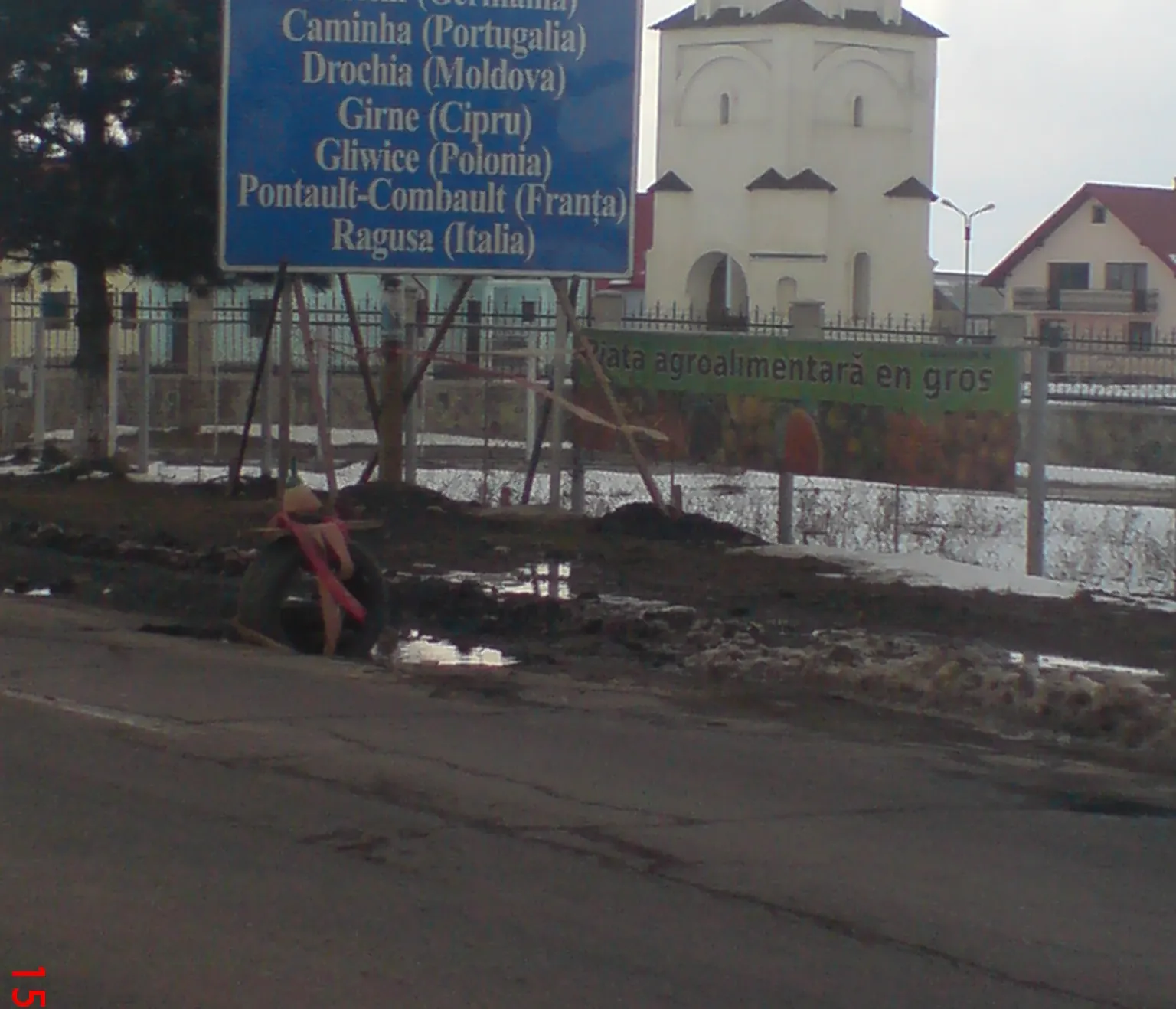 Groapă în astfalt semnalizată cu o anvelopă şi o sticlă de bere