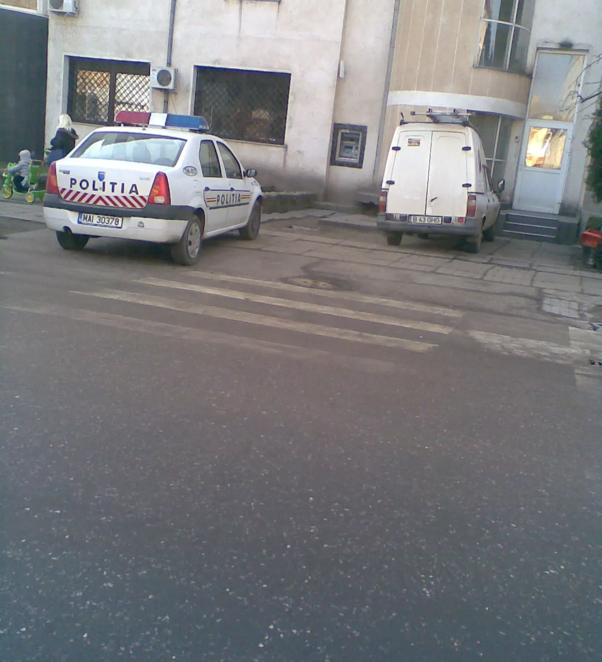 O maşină a poliţiei a fost parcată pe trotuar, exact lângă trecerea de pietoni