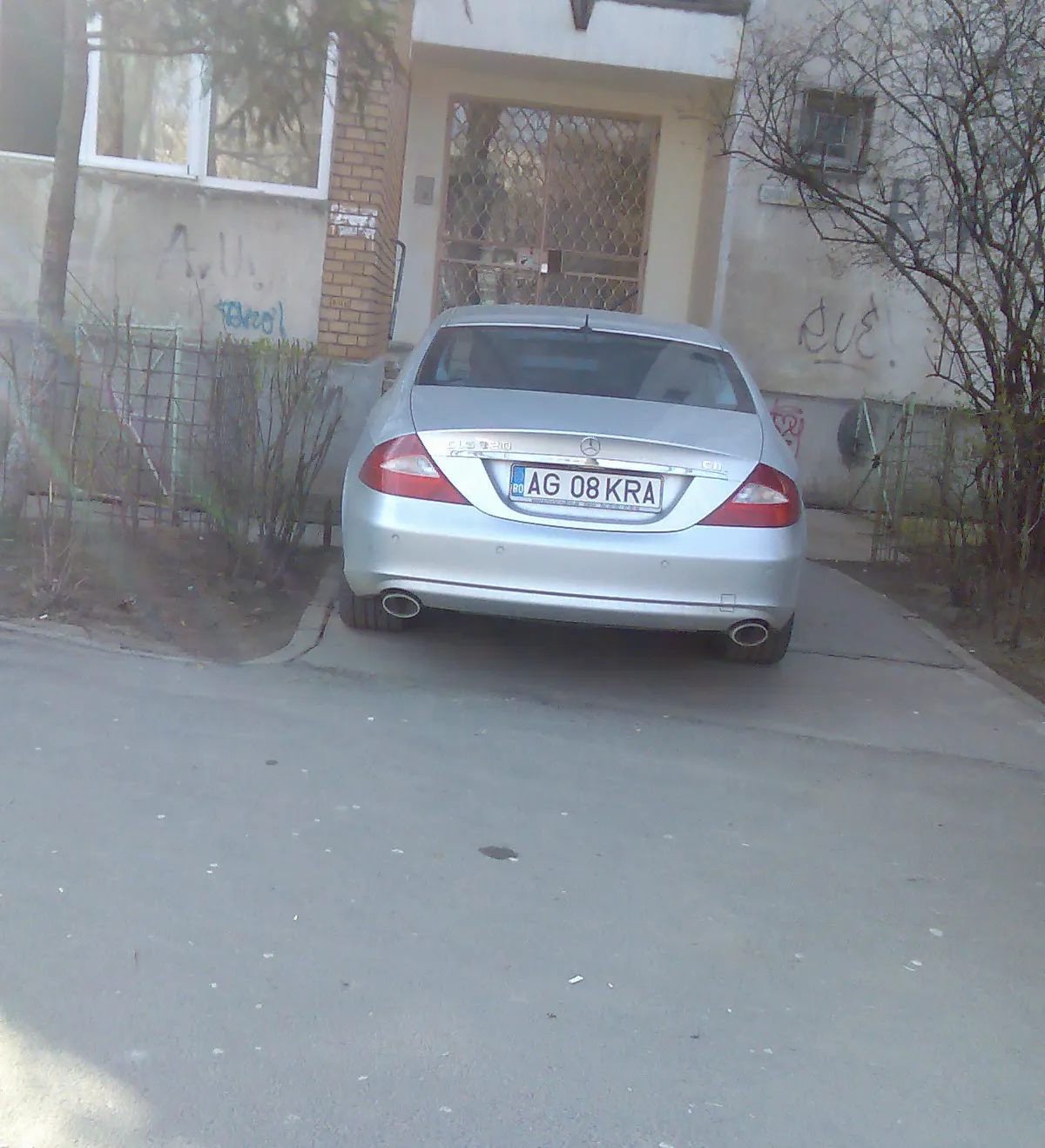 Maşină parcată în dreptul uşii de intrare în bloc, în Argeş