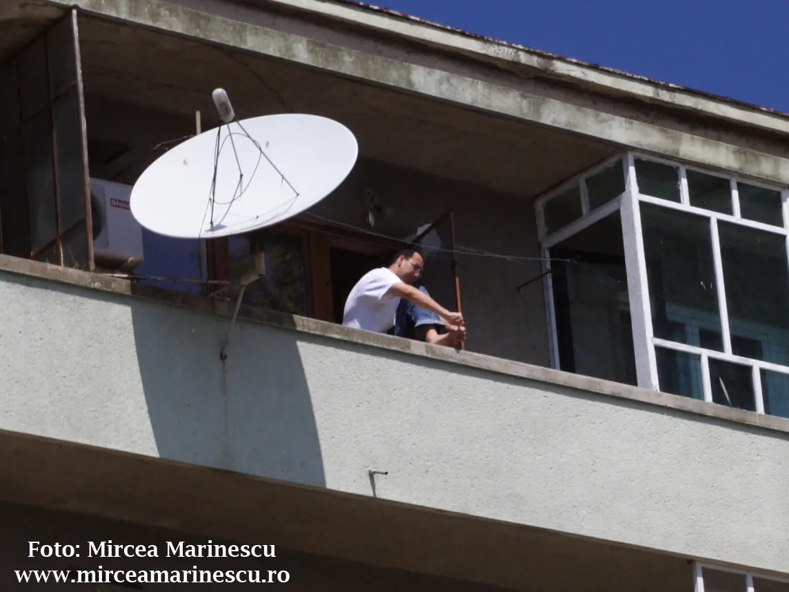 Deasupra falezei din Constanţa, un locatar îşi face pedichiura pe balcon