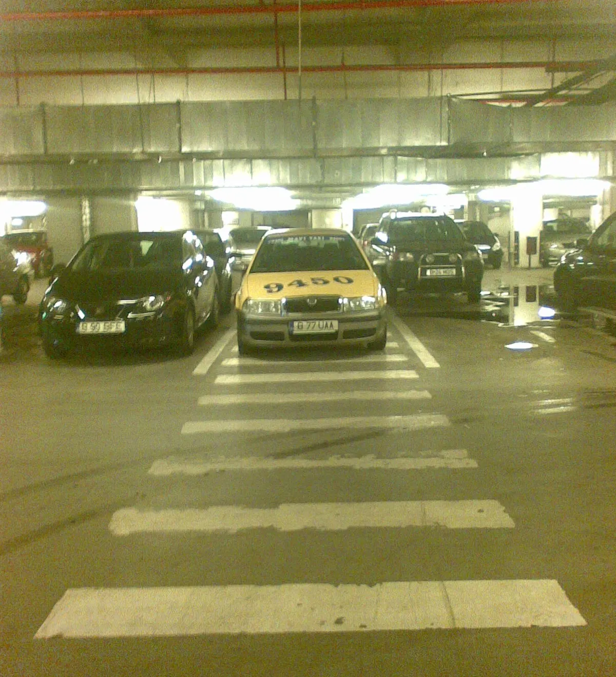 Taxi parcat pe trecerea de pietoni, în parcarea unui supermarket