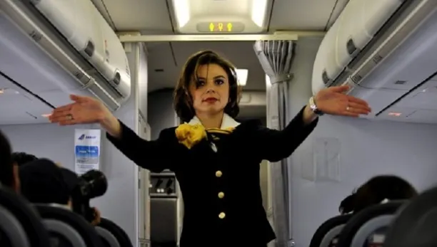 De ce ţin stewardesele mâinile la spate atunci când pasagerii urcă în avion