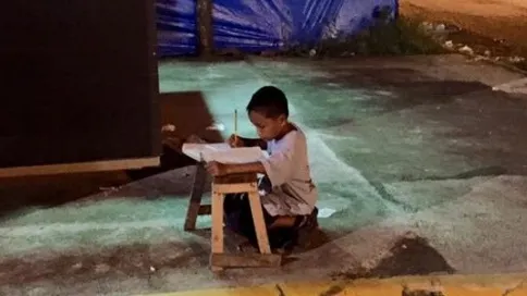 Acest micuț își făcea temele în stradă, la lumina unei vitrine. Ce a urmat, este IREAL!