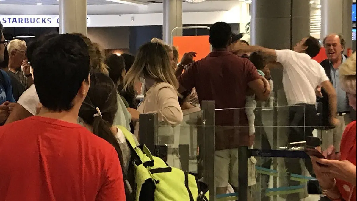 Imagine şocantă: un bărbat care îşi ţine bebeluşul în braţe, lovit de un angajat al aeroportului